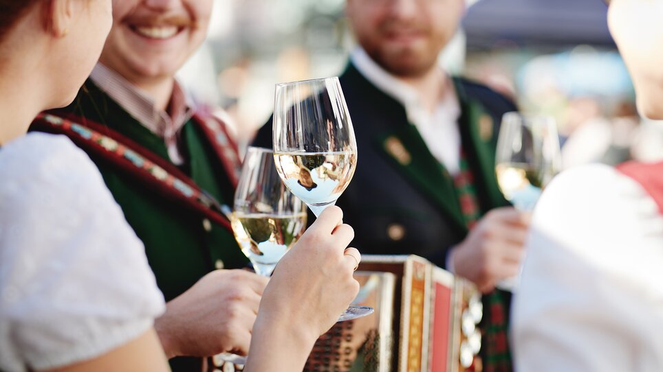 Personen mit Weingläsern und einem Akkordeon. Festliche Stimmung. | © BIO AUSTRIA Steiermark - Königshofer