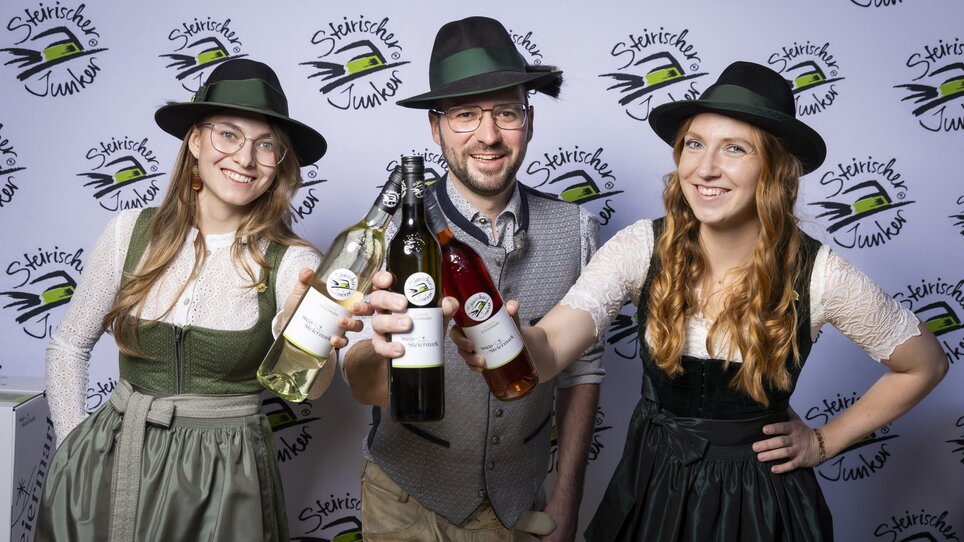 Three individuals presenting drinks at a wine tasting event in Graz. | © Wein Steiermark - Werner Krug