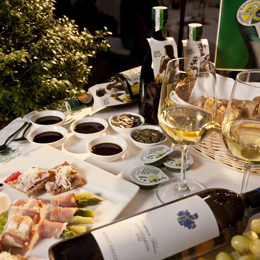 Ein Tisch mit verschiedenen Speisen, Weinen und Kürbiskernöl. | © Graz Tourismus - Werner Krug