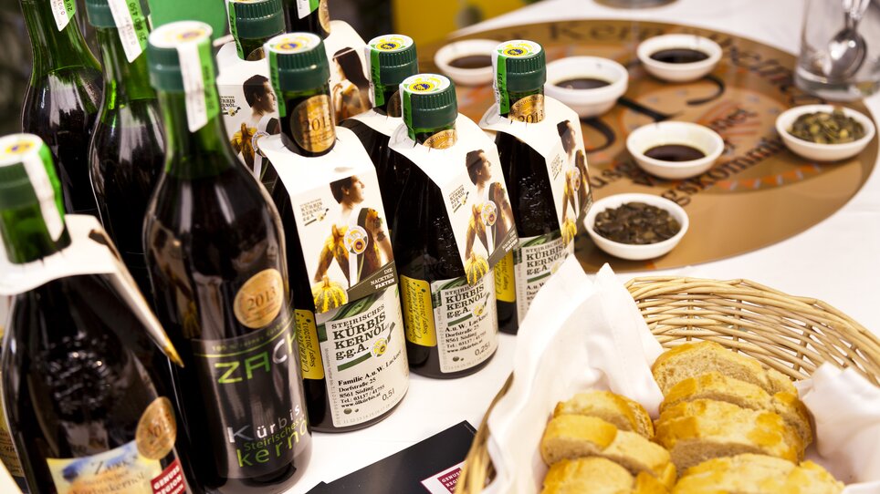 Eine Reihe von Kernölflaschen und frischem Brot bei einer Verkostung. | © Graz Tourismus - Werner Krug