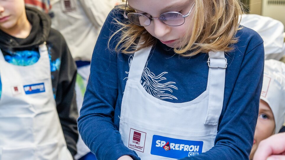 Ein Kind schneidet Zwiebeln bei einem Kochkurs für Kinder in Graz. | © Graz Tourismus - Paul Stajan