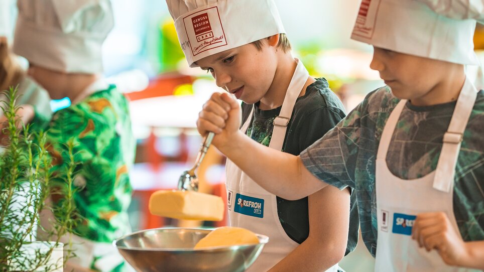 Kinder mit Kochmützen bei einem Kochkurs in Graz. | © KHC - Bernhard Schindler