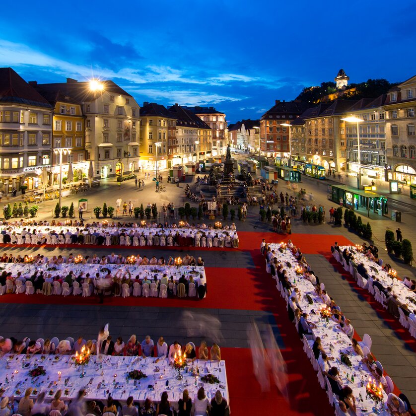Lange Tafel der GenussHauptstadt in Graz I Steiermark | © Graz Tourismus - Harry Schiffer Festliche lange Tafel in Graz bei Dämmerung mit Gästen. | © Graz Tourismus - Harry Schiffer