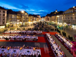 Festliche lange Tafel in Graz bei Dämmerung mit Gästen. | © Graz Tourismus - Harry Schiffer