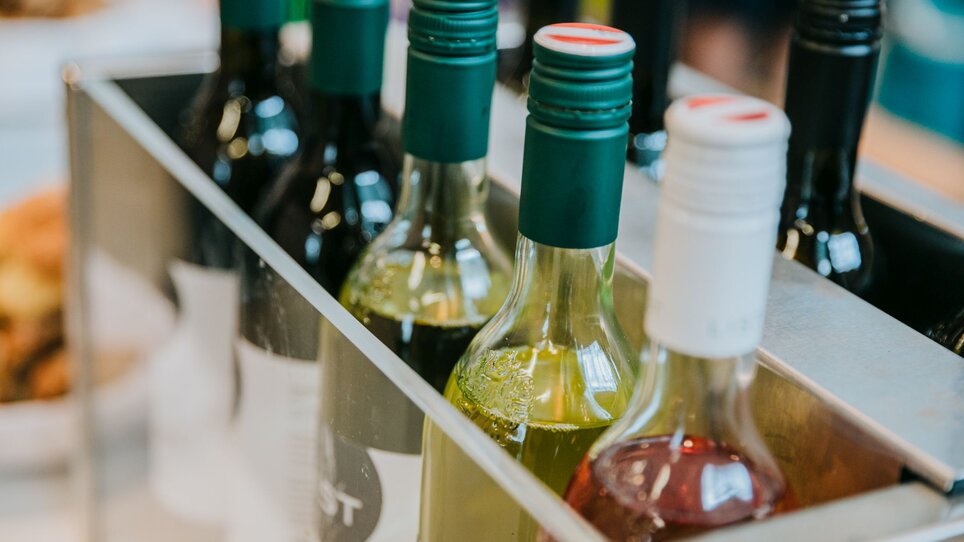 Eine Auswahl von Weinflaschen in einem Regal, darunter rote und weiße Weine. | © Wein Steiermark - Johanna Lamprecht