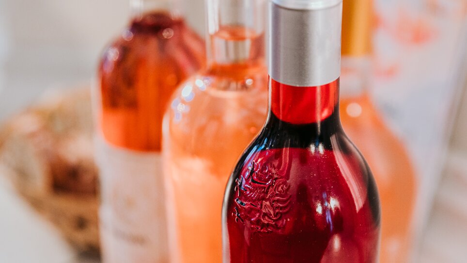 Nahaufnahme von drei Weinflschen mit Wein in unterschiedlichen Rosétönen, von zartem Pfirischrosa bis zu kräftigem hellen Rot. | © Johanna Lamprecht