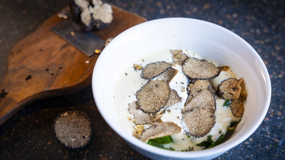 A bowl of creamy sauce topped with fresh truffles and herbs. | © Graz Tourismus - Werner Krug