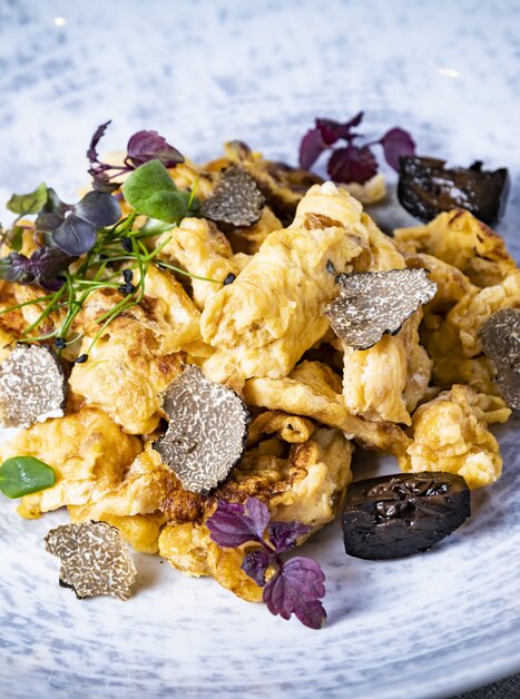 A dish featuring scrambled eggs, truffles, mushrooms, and fresh herbs. | © Graz Tourismus - Werner Krug