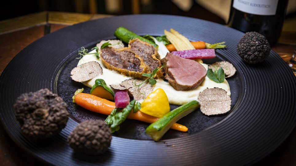Un piatto splendidamente presentato con carne, verdure e tartufi. | © Graz Tourismus - Werner Krug