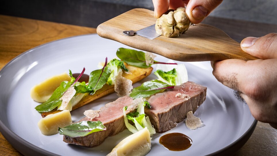 Un piatto con tartufo, manzo e erbe fresche. | © Graz Tourismus - Werner Krug