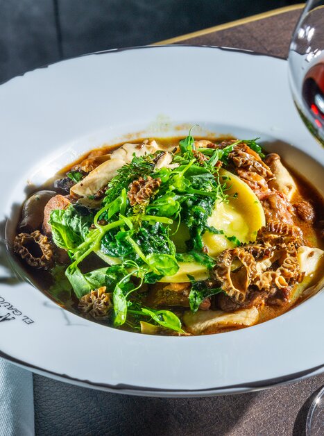 Un piatto di pasta, tartufi e erbe fresche, servito con un bicchiere di vino rosso. | © Paul Stajan
