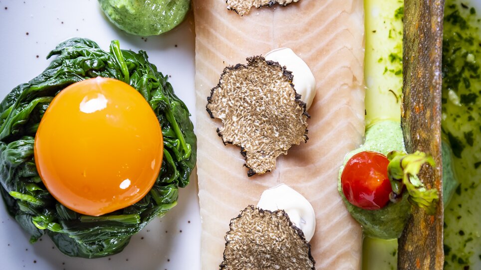 Un piatto splendidamente presentato con pesce, tartufo, tuorlo d'uovo e varie guarnizioni. | © Graz Tourismus - Werner Krug
