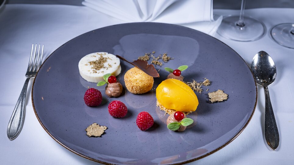 An elegant dessert with truffles on a round plate. | © Graz Tourismus - Werner Krug