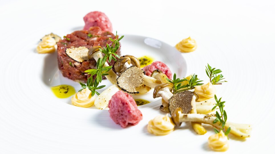 An artistic dish featuring beef tartare, truffles, and mushrooms on a plate. | © Graz Tourismus - Werner Krug