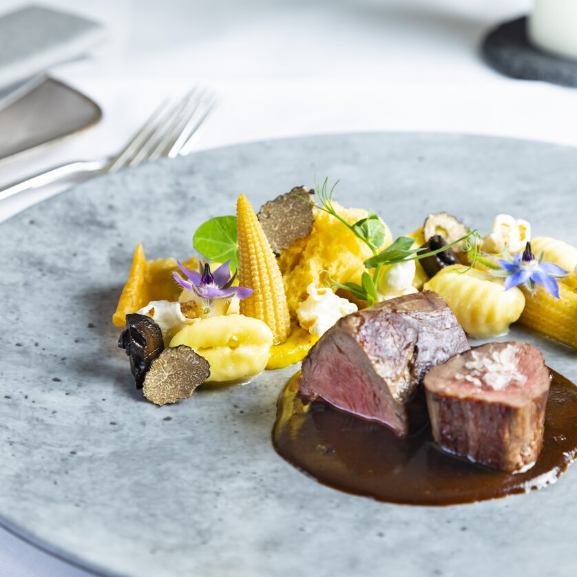 Ein exquisit angerichteter Teller mit Rindfleisch, Beilagen und Trüffeln. | © Graz Tourismus - Werner Krug