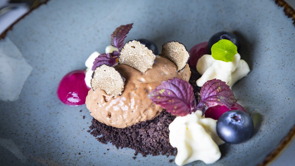 Un dessert di mousse al cioccolato guarnito con fette di tartufo, bacche e panna. | © Graz Tourismus - Werner Krug