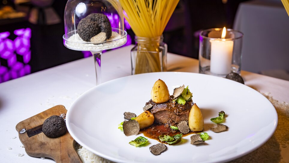A gourmet dish featuring truffle, meat, and sides on an elegant plate. | © Werner Krug