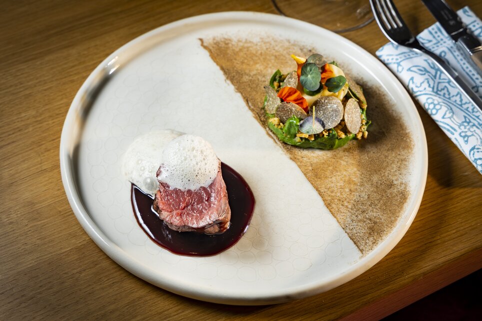 Trüffelfestival in der GenussHauptstadt Graz I Stammtisch am Paulustor | © Graz Tourismus - Werner Krug Ein elegantes Gericht mit Rinderfilet, einer Sauce und Beilagen, serviert auf einem modernen Teller. | © Graz Tourismus - Werner Krug