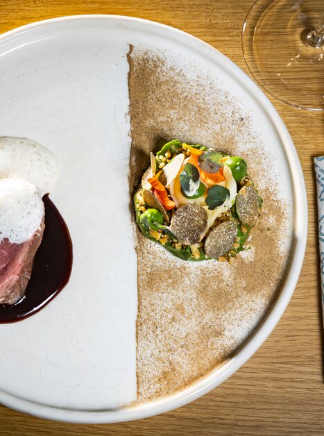 Un piatto artisticamente disposto con carne, salsa e verdure. | © Graz Tourismus - Werner Krug