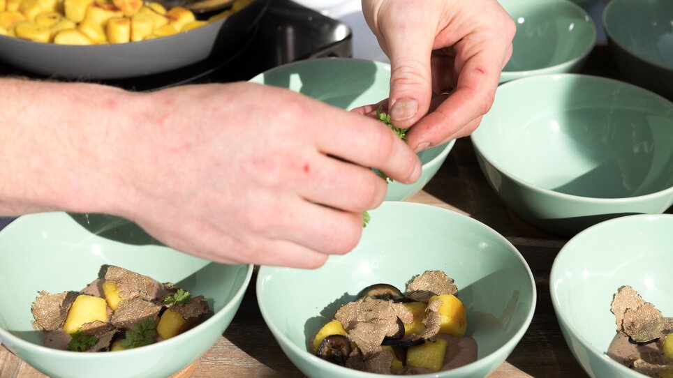 Chef garnishes plates with truffle, potatoes, and mushrooms for the truffle festival. | © Graz Tourismus - Harry Schiffer