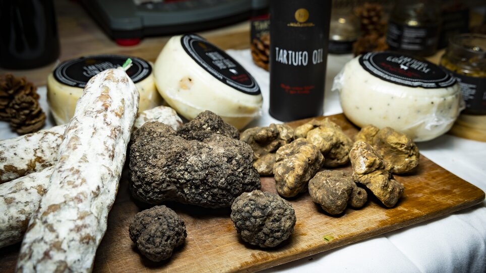 A variety of truffles, cheese, and truffle oil on a wooden board. | © Graz Tourismus - Werner Krug