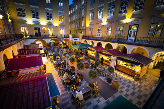 Gemütlicher Trüffelmarkt im Paradeishof mit beleuchteten Ständen und Gästen. Abendlich beleuchtet mit schönen Umgebungen. | © Graz Tourismus - Werner Krug