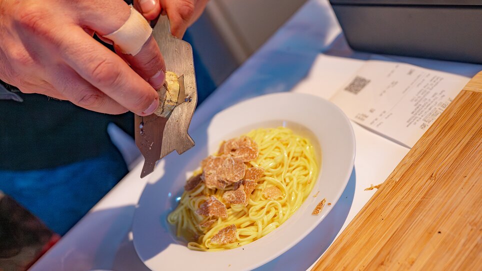 A chef grates fresh truffle over spaghetti with sauce. | © 5komma5sinne - Rene Strasser