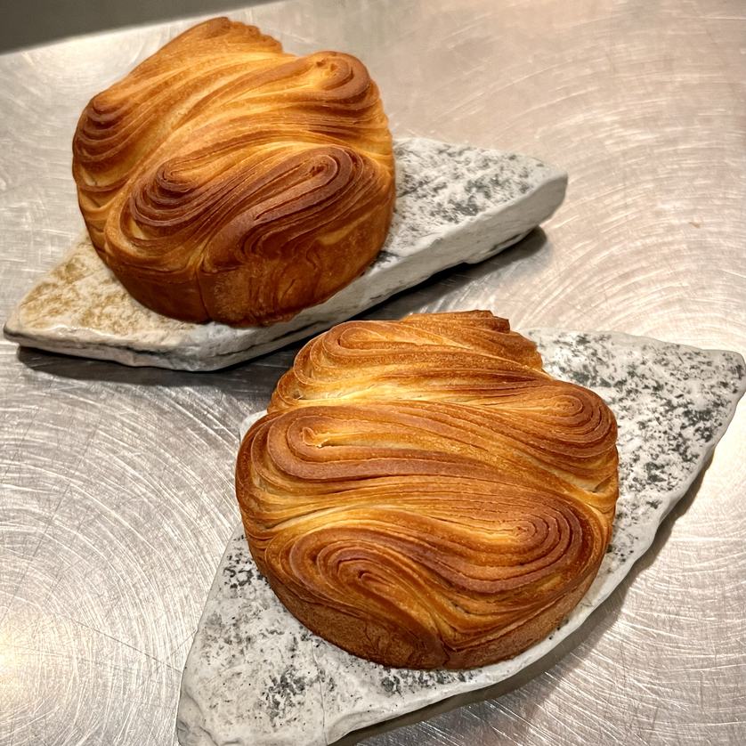 Zwei kunstvoll geformte Blätterteiggebäck-Stücke auf edlen Platten. | © Jaimy Reisinger