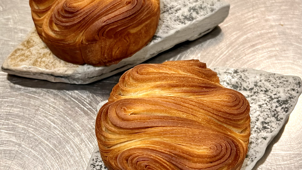 Zwei kunstvoll geformte Blätterteiggebäck-Stücke auf edlen Platten. | © Jaimy Reisinger