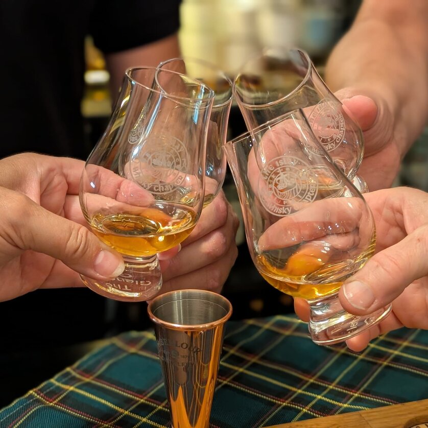 Vier Hände heben Whiskygläser zum Anstoßen. | © The Islay Whisky Chapter Austria