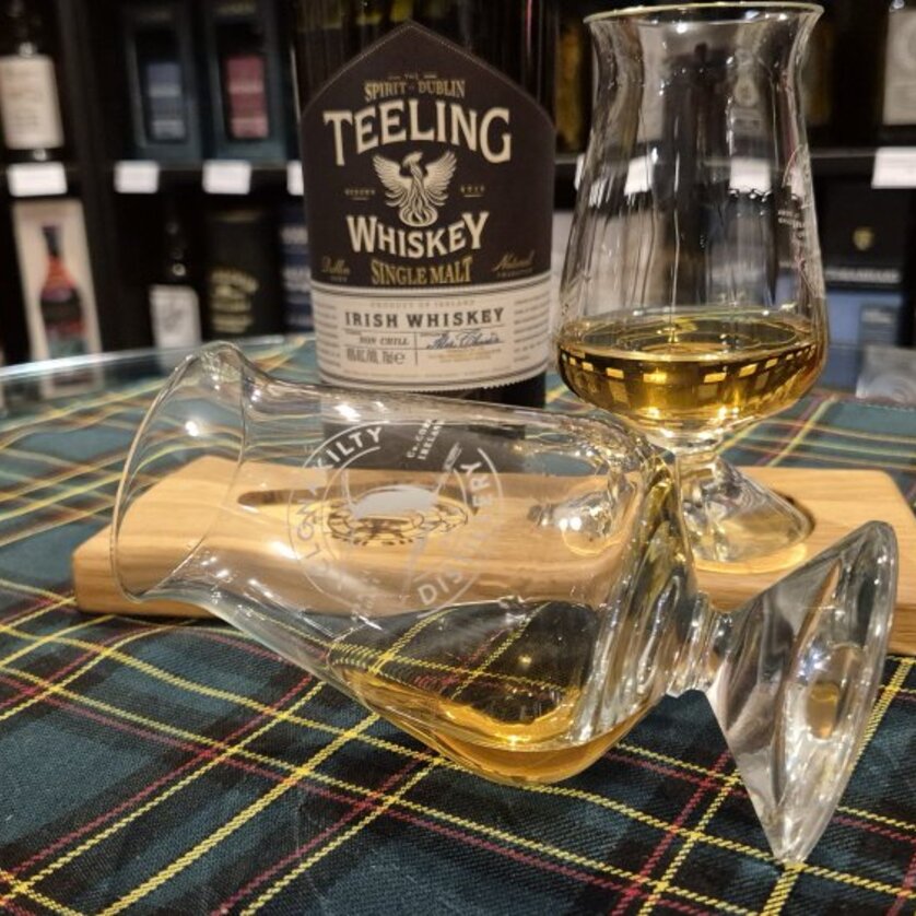Eine Whiskey-Flasche mit zwei Gläsern auf einem Schottenmuster-Tuch. | © The Islay Whisky Chapter Austria