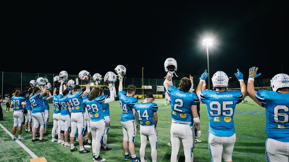 Players from the Styrian Bears American football team are raising their helmets in the air. | © Georg Obetzhofer