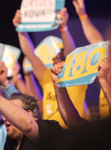 Spectators displaying signs reading 180 at a tournament. | © PDC EuropeLangenbahn von Moltke GmbH