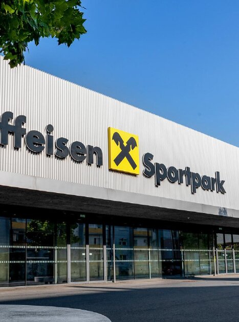 Ansicht des Raiffeisen Sportparks mit klarem Himmel. Gebäude mit großen Fenstern. | © Raiffeisen Sportpark