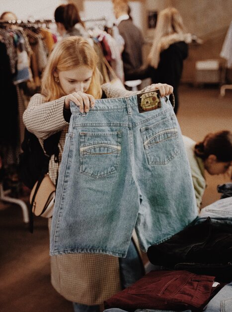 Eine Frau betrachtet Jeans in einem Vintage-Verkauf. | © BeThrifty