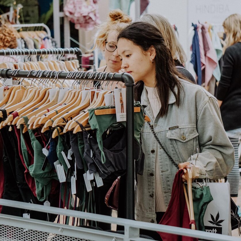 Zwei Frauen schauen sich Kleidung auf einem Markt in Graz an. | © Kunst- und Designmarkt