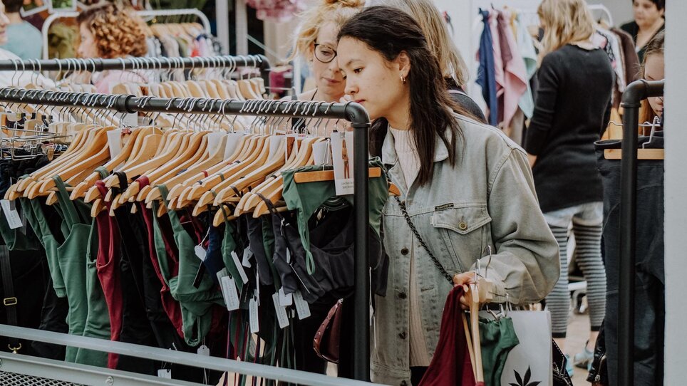 Zwei Frauen schauen sich Kleidung auf einem Markt in Graz an. | © Kunst- und Designmarkt