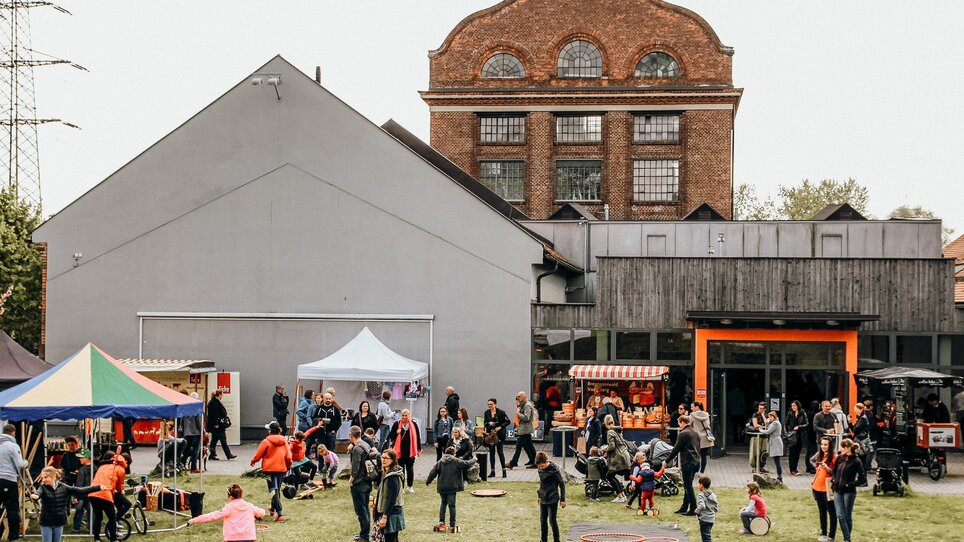 Ein belebter Markt mit Ständen, Besuchern und Aktivitäten im Freien. | © Kunst und Designmarkt