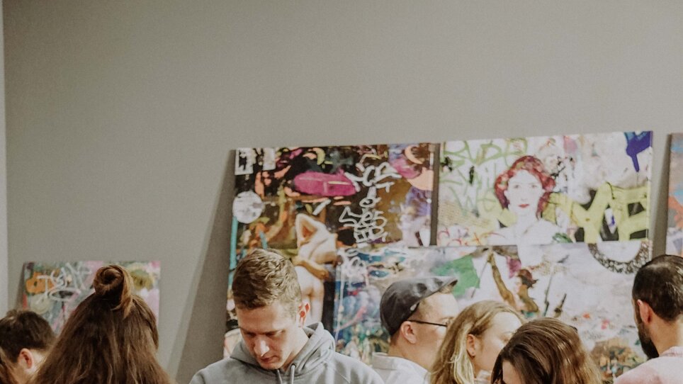 Besucher betrachten Kunstwerke auf dem Kunst- und Designmarkt in Graz.