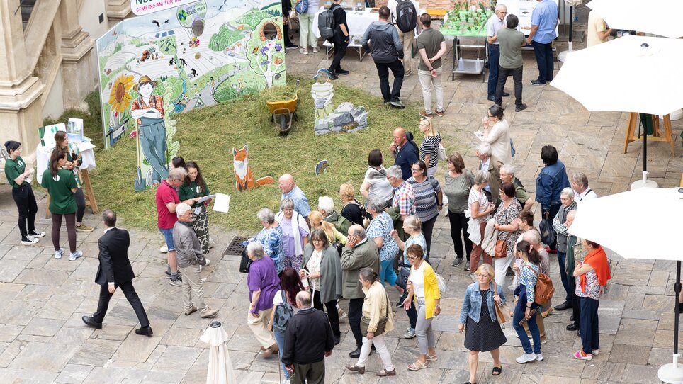 People exploring an outdoor event with stalls. | © Harry Schiffer