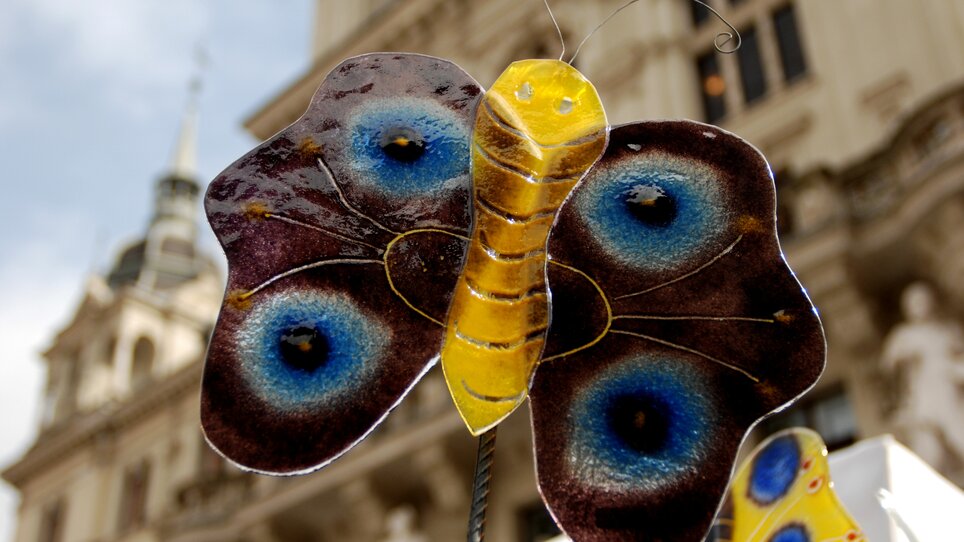 Ein kunstvoller Glasfalter vor einer historischen Kulisse in Graz. | © Graz Tourismus - Jane Hinterleitner