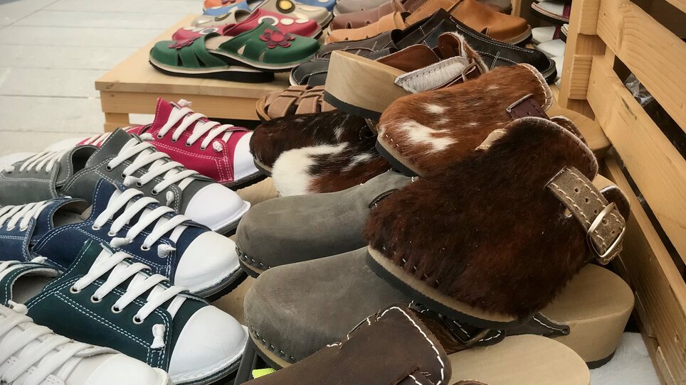 Colorful selection of shoes at a market, various styles and colors. | © KIKH 3