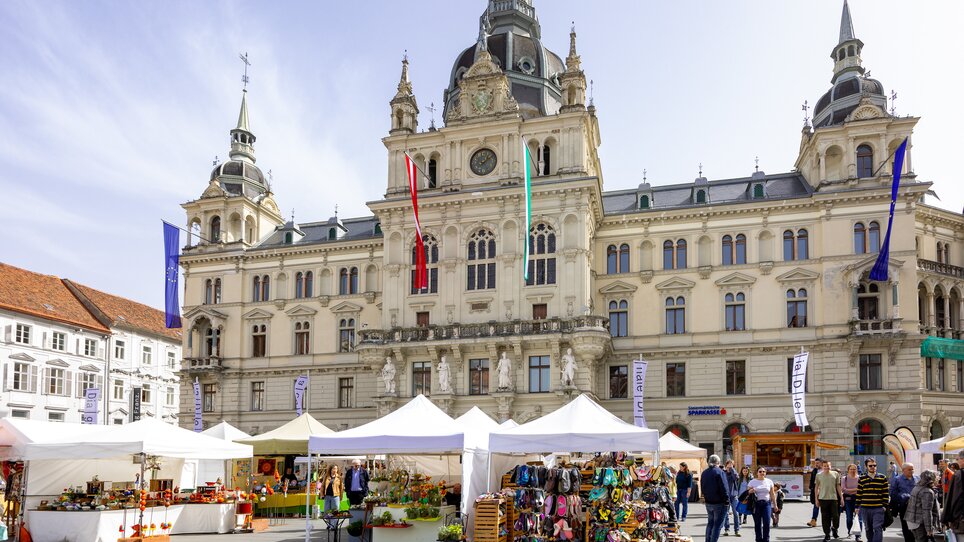 Market stalls on the main square in Graz in front of the historic façade of the town hall. | © Graz Tourismus  - Harry Schiffer