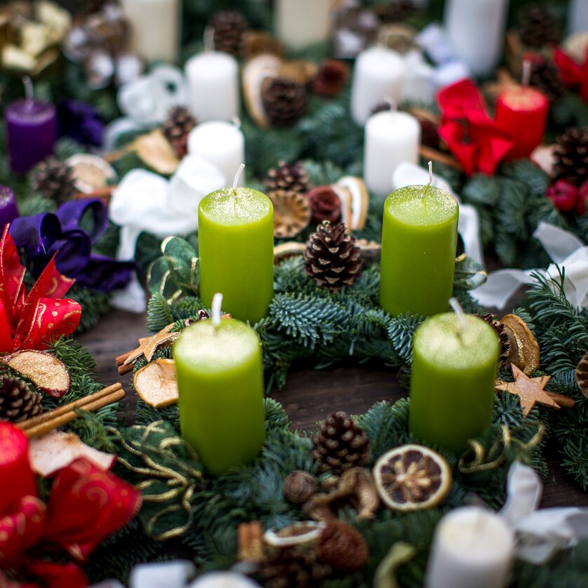 Colorful Advent wreaths with various candles, pine branches, and decorations. | © Graz Tourismus - Tom Lamm