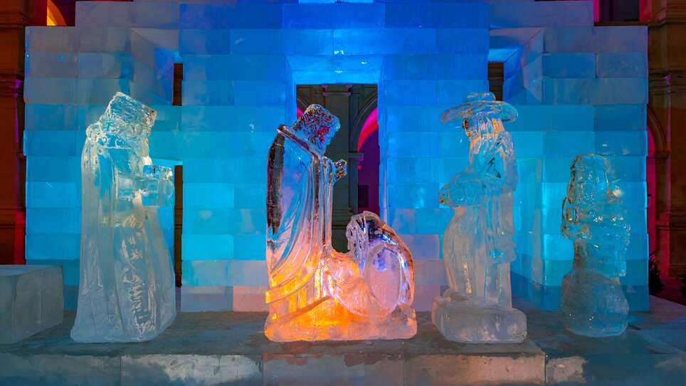 Scultura di ghiaccio che rappresenta figure della natività, illuminata con luci colorate. | © Graz Tourismus - Harry Schiffer