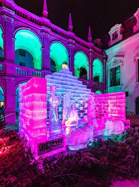 Ice nativity scene in Graz's Landhaus courtyard, illuminated with colorful lights. | © Region Graz - Harry Schiffer