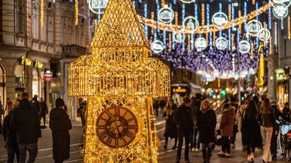 Beleuchtete Skulptur eines Uhrturms in der Herrengasse in Graz. | © achtzigzehn - Hinterleitner