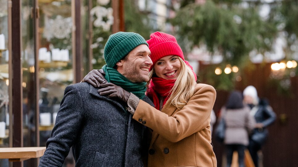 Couple in winter clothing surrounded by Christmas lights in Graz. | © Graz Tourismus - Mias Photoart