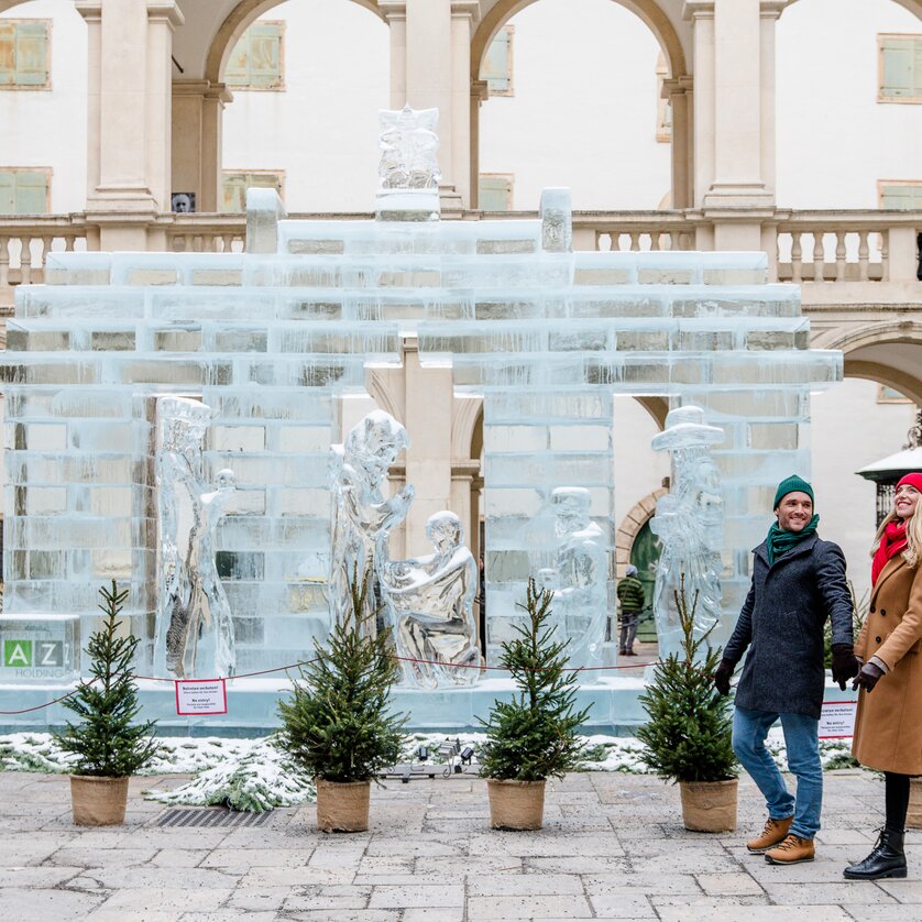 Ein Paar spaziert vor einer imposanten Eisskulptur in Graz. | © Graz Tourismus - Mias Photoart