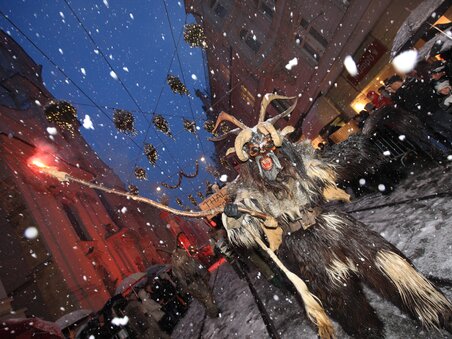 Ein Percht in traditioneller Verkleidung bei einer Parade in Graz während des Schneefalls. | © Graz Tourismus - Harry Schiffer